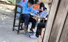 Niños indígenas estudian bajo un árbol en Puerto Pinasco