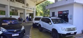 Vehículos estacionados frente a la Dirección de Tránsito de Asunción, mientras ciudadanos realizan gestiones administrativas en el lugar, en una jornada con alta concurrencia.