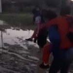 Puerto Casado: madres cargan a sus hijos para cruzar calle inundada